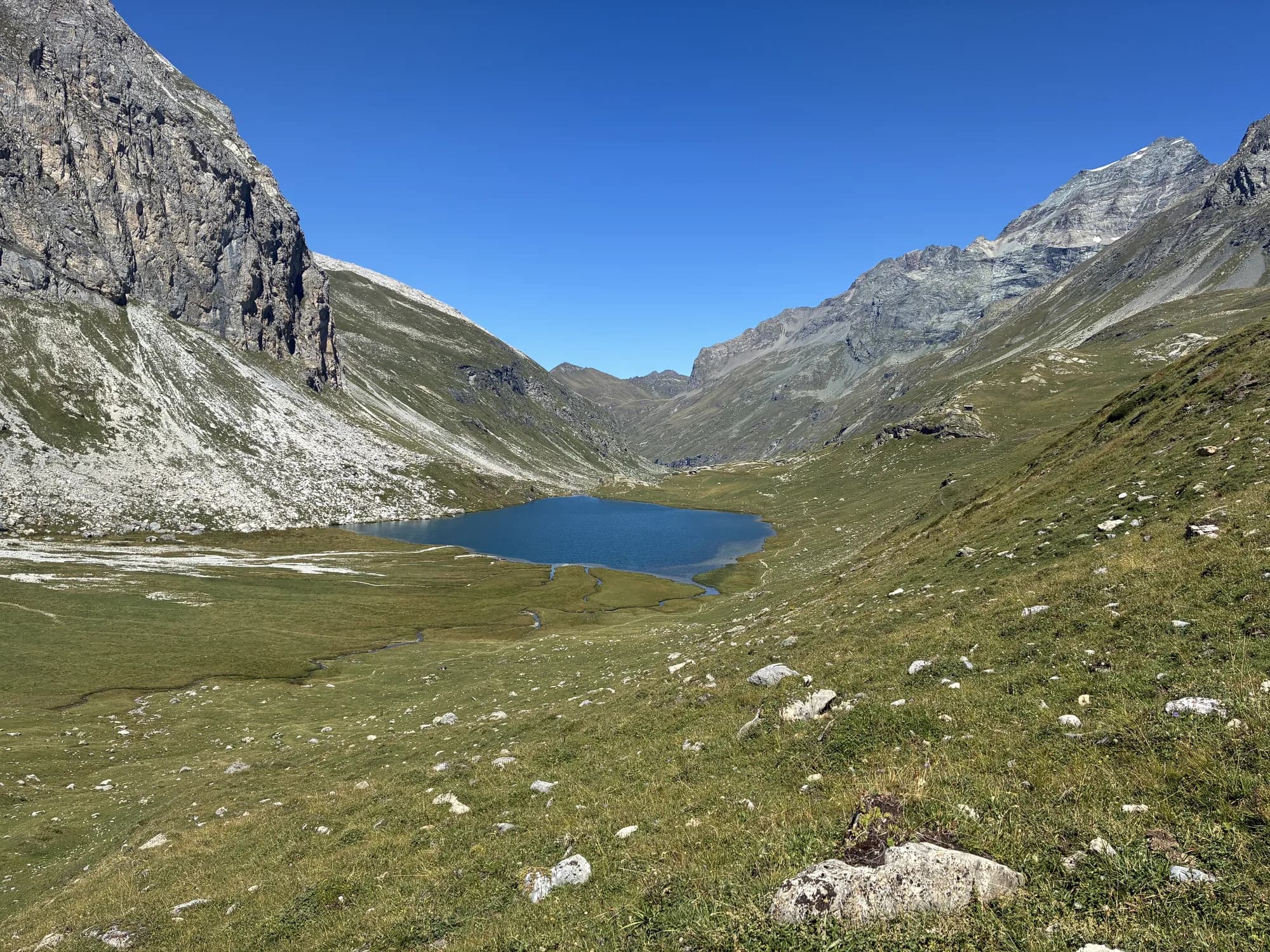 Lac d'altitude niché dans un cirque de montagnes, en été